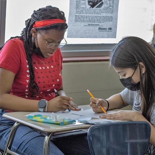  Students collaborate at a desk